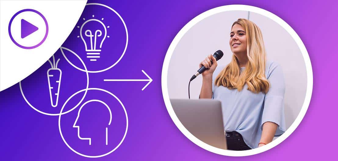 A woman with long blonde hair speaks into a microphone, standing behind a laptop. The background is purple with icons of a head, carrot, and lightbulb connected by arrows, and a play button in the top left corner.