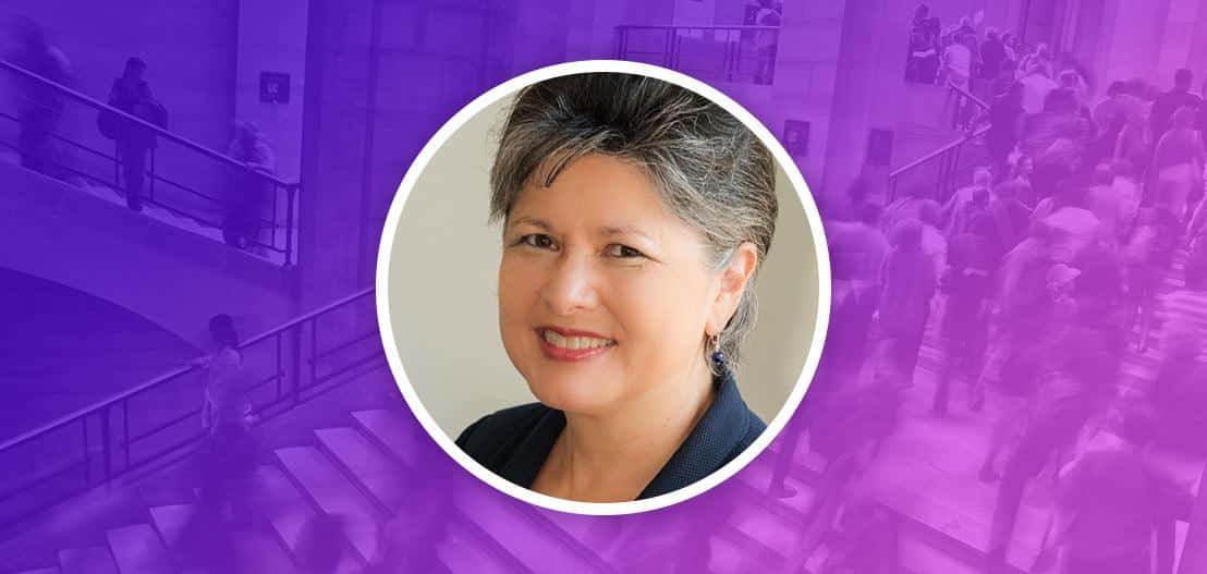 A woman with short hair smiles in a circular frame on a purple background. The background features a faded image of people walking up and down stairs.
