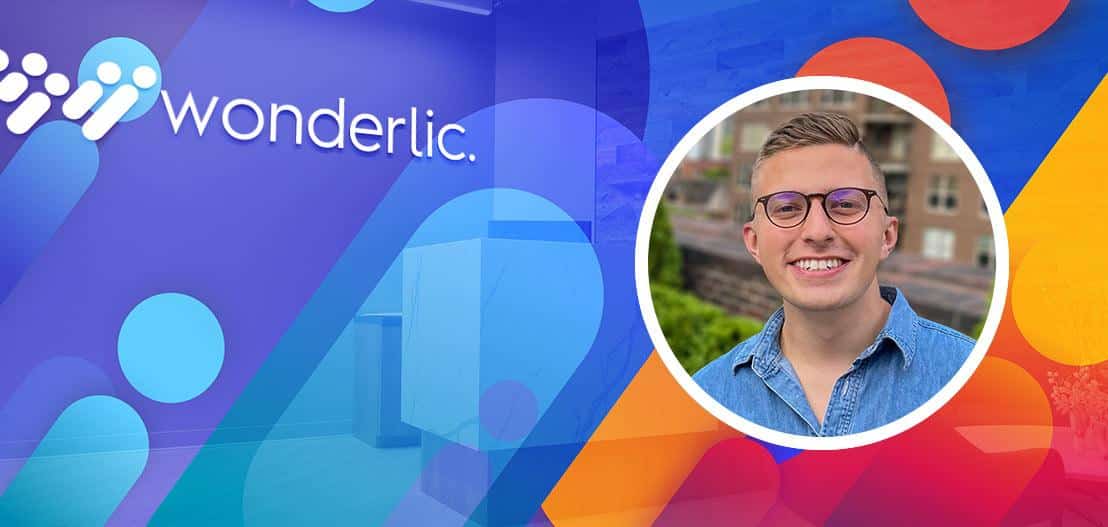 Colorful graphic featuring the Wonderlic logo on the left with abstract shapes. On the right is a circular inset photo of a person wearing glasses and a denim shirt, smiling against an outdoor backdrop.