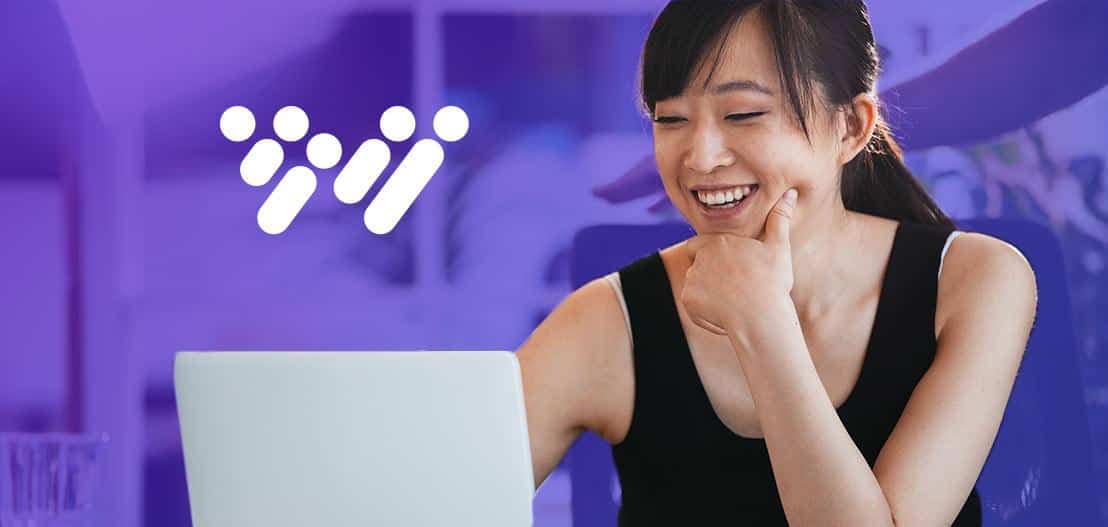 A woman smiling while using a laptop, with a purple background and a white logo consisting of four dots and a line. She is wearing a black tank top and has her hair tied back.