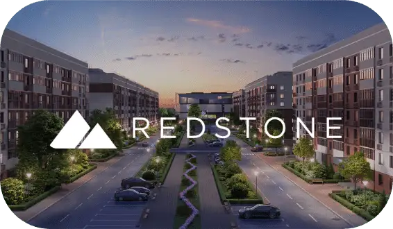 The Redstone Residential logo over one of their apartment communities at dusk