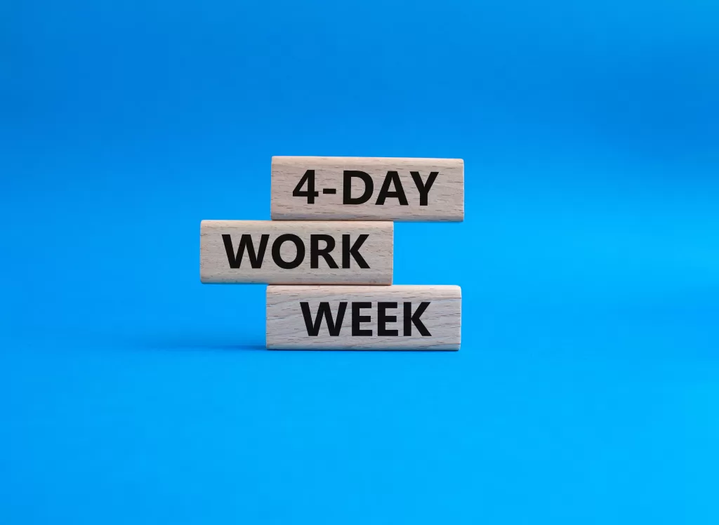 4-day workweek symbol. 4-day workweek on wooden blocks. Beautiful blue background. Business and 4-day workweek concept.