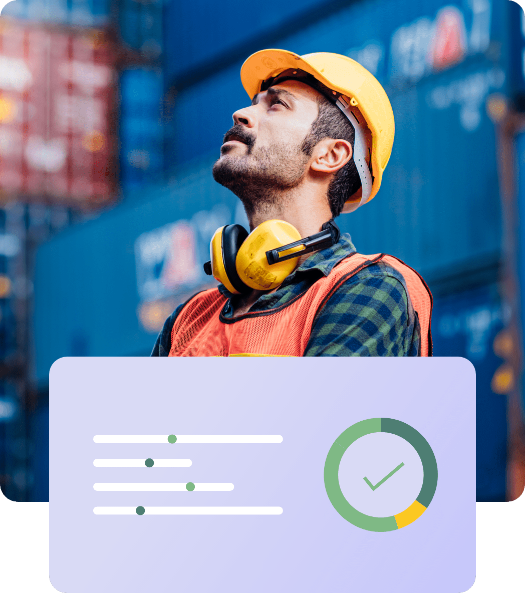 A construction worker wearing a yellow hard hat and earmuffs looks upward. Dressed in an orange safety vest and a checkered shirt, he's standing in front of stacked shipping containers. In the foreground, there is a graphic showing a progress chart and a checkmark, symbolizing the Hiring Assessment process.