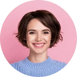 A woman with short brown hair is smiling at the camera in a light blue sweater against a pink background. Get started with a Wonderlic demo to see why she's so confident.