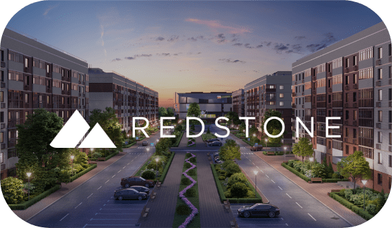 A dusk view of a modern apartment complex with multiple buildings, well-maintained landscaping, and parked cars along the road. The foreground features a logo with two white triangle shapes and the text "REDSTONE" in capital letters—ideal for your hiring assessment backdrop.