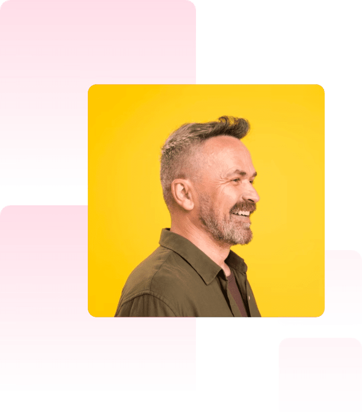 Portrait of a smiling man with a beard and short hair, wearing a button-up shirt. He is looking to the right against a vibrant yellow background. The image is overlaid on abstract pink shapes.
