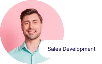 A smiling person with short brown hair and a light teal collared shirt is in front of a pink background. Next to the image, there is a label that reads "Sales Development.