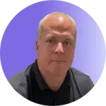 A man with short hair, wearing a dark polo shirt, looks at the camera with a neutral expression. The gradient blue and purple background adds a calm atmosphere suited for effective coaching.